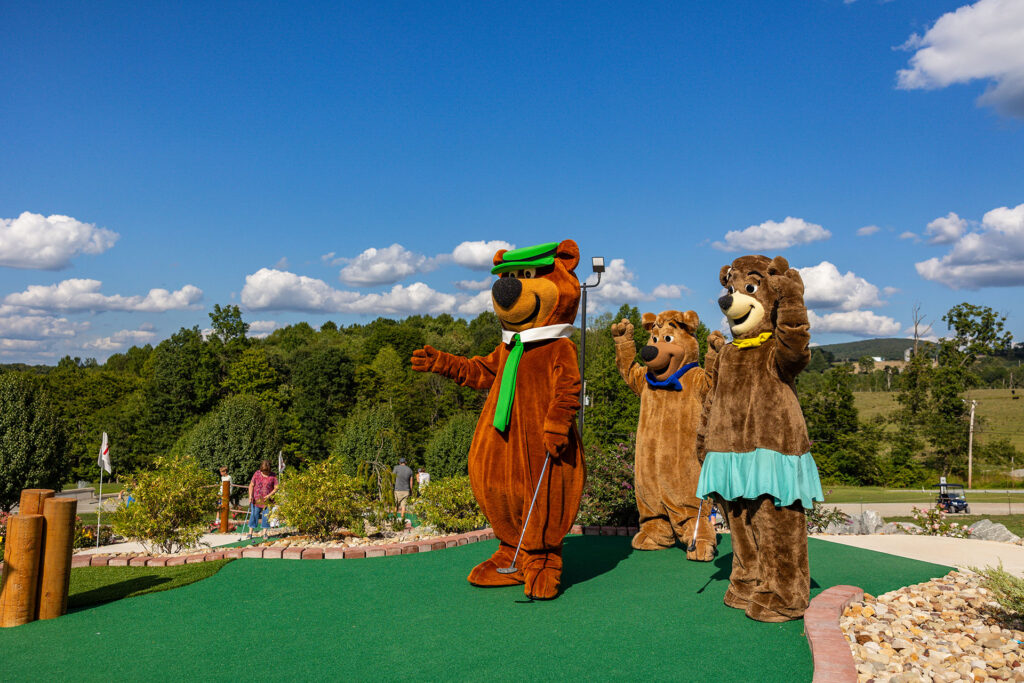 Yogi Bear, Boo Boo & Cindy Bear on the Mini Golf Course | Jellystone Park™ Mill Run Yogi Bear, Boo Boo, and Cindy Bear playing mini golf at Jellystone Park™ Mill Run in Pennsylvania.
